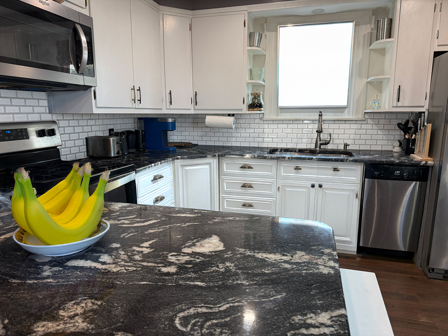Finished kitchen backsplash with glass subway tiles
